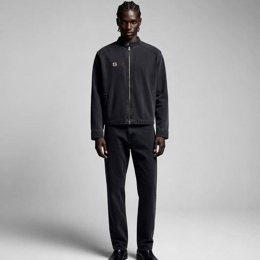 Person wearing a black jacket and pants on a gray background