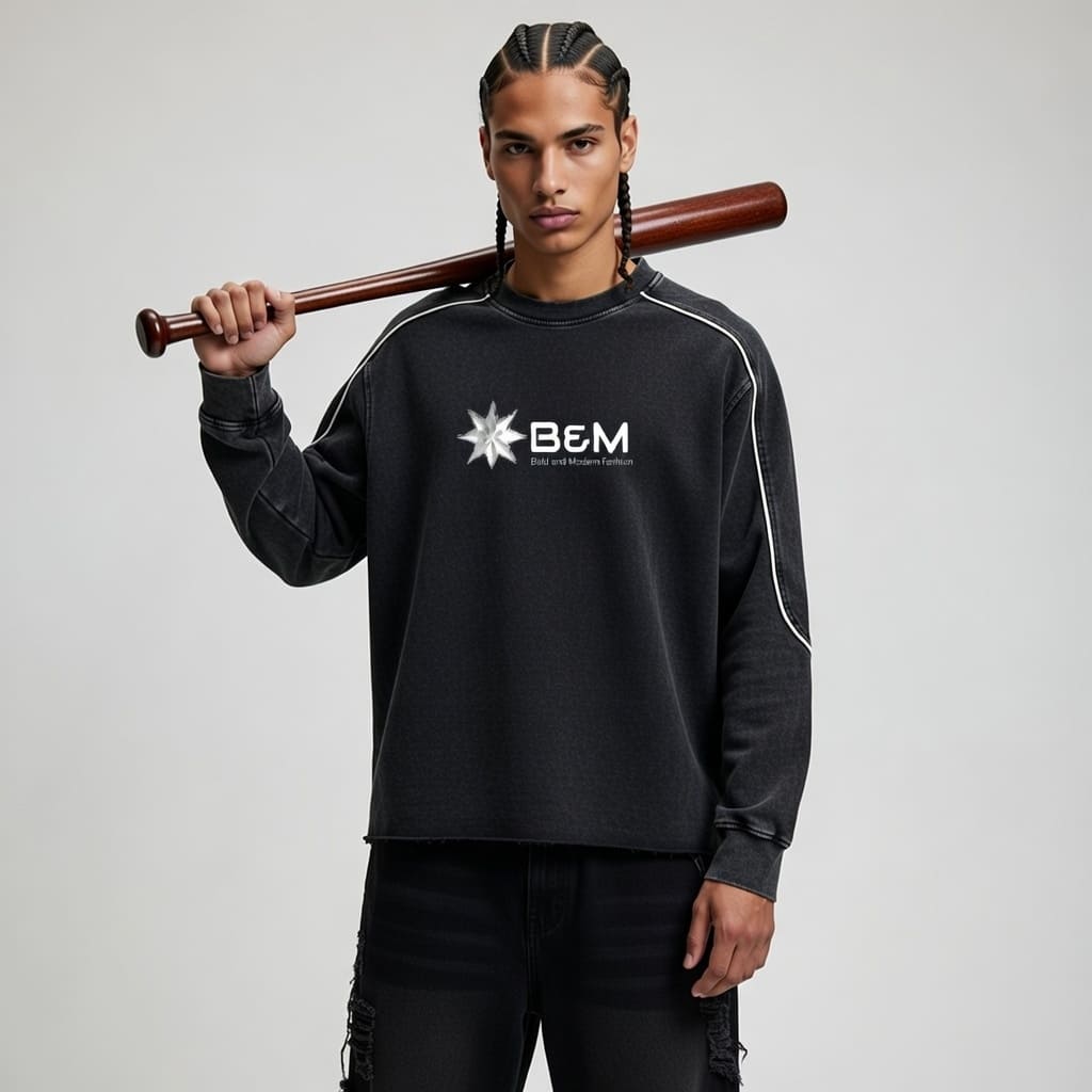 Person wearing a black sweatshirt with 'B&M' logo holding a baseball bat against a gray background