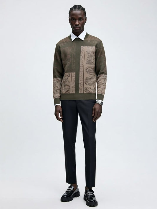 Man wearing a patterned sweater and black pants on a white background